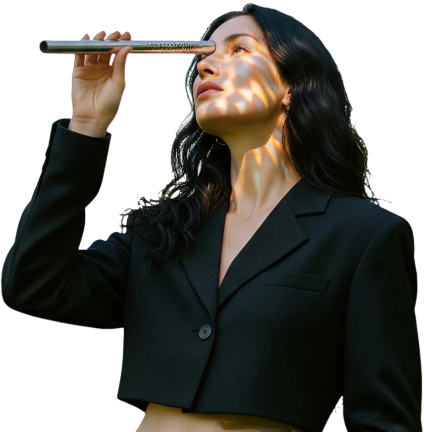 A woman in a black suit looking through a kaleidoscope